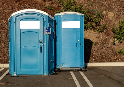 wheel chair accessible ada portable toilet in parking lot